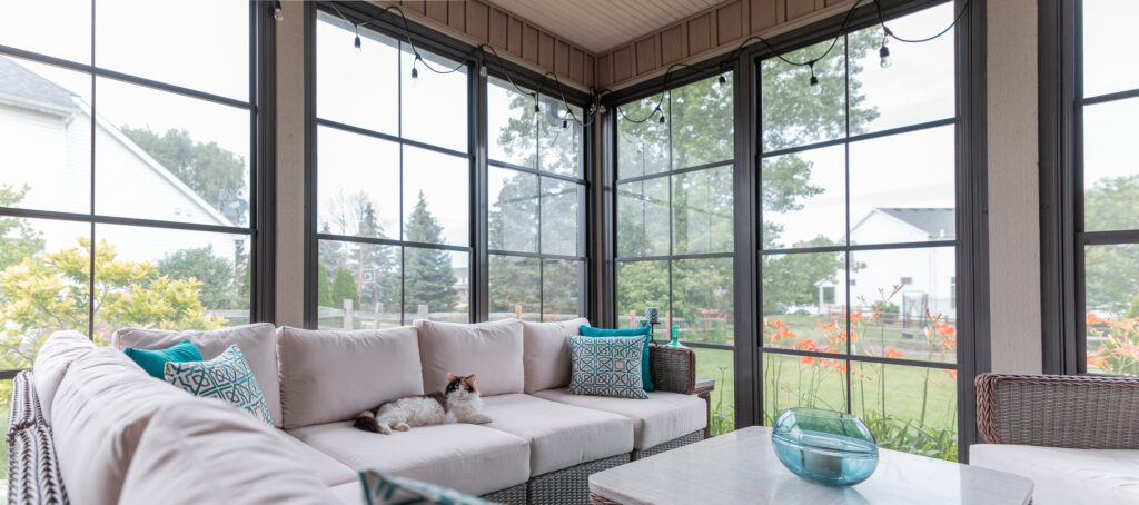Kim's porch enclosed with bronze-frame vertical 4-track sliders