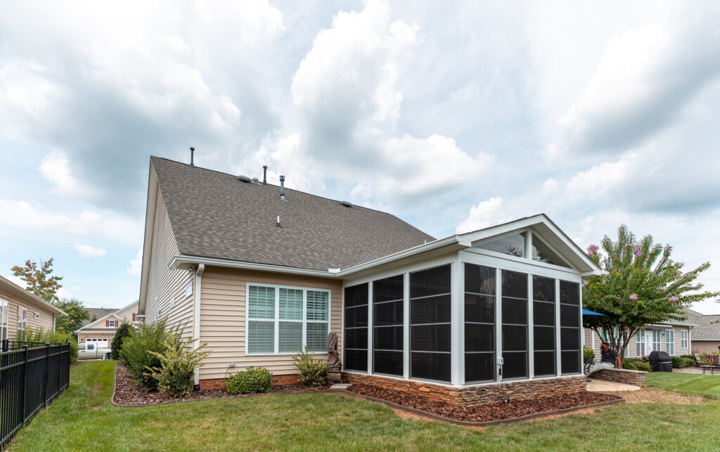 Exterior of a home with an enclosed porch in bronze frames